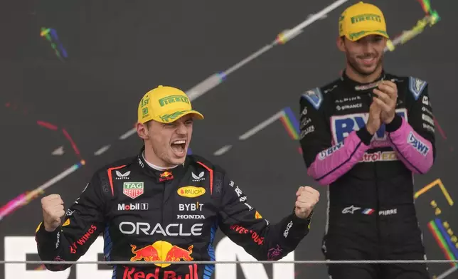 Red Bull driver Max Verstappen, of the Netherlands, left, celebrates on the podium his first place in the Brazilian Formula One Grand Prix at the Interlagos race track in Sao Paulo, Sunday, Nov. 3, 2024.(AP Photo/Andre Penner)