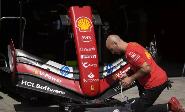 A crew member works on the car of Ferrari driver Charles Leclerc, of Monaco, ahead of the Brazilian Formula One Grand Prix at the Interlagos race track in Sao Paulo, Brazil, Thursday, Oct. 31, 2024. (AP Photo/Andre Penner)