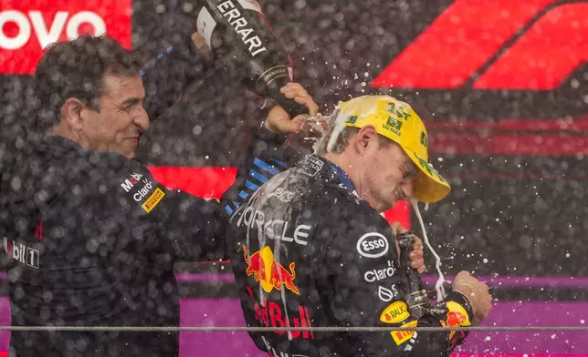 Red Bull technical chief Pierre Wache sprays driver Max Verstappen, of the Netherlands, on the podium after he won the Brazilian Formula One Grand Prix at the Interlagos race track in Sao Paulo, Sunday, Nov. 3, 2024. (AP Photo/Andre Penner)