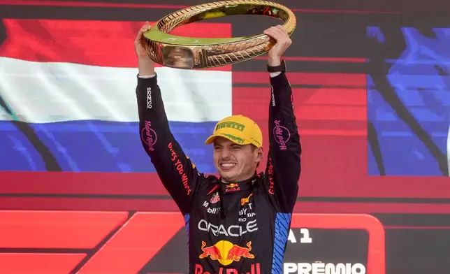 Red Bull driver Max Verstappen, of the Netherlands, celebrates on the podium his first place in the Brazilian Formula One Grand Prix at the Interlagos race track in Sao Paulo, Sunday, Nov. 3, 2024. (AP Photo/Andre Penner)