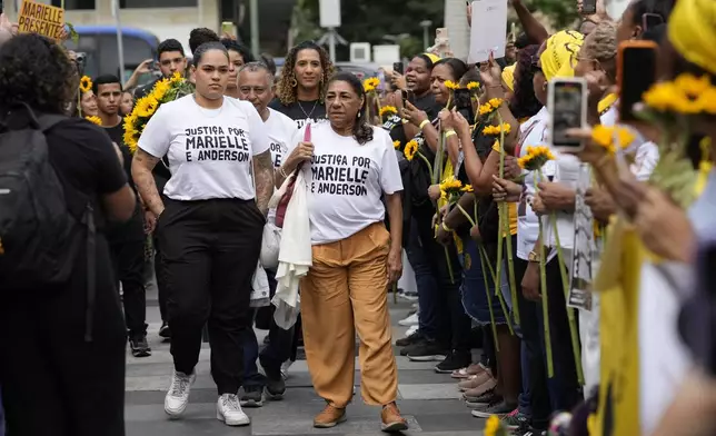 Mother of slain councilwoman Marielle Franco, Marinete Silva, right center, and Luyara Santos, left center, daughter of slain councilwoman Marielle Franco, accompanied by other family members, arrive to follow the trial of former city councilwoman Marielle Franco's alleged killers, in Rio de Janeiro, Brazil, Wednesday, Oct. 30, 2024. (AP Photo/Silvia Izquierdo)