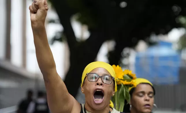 A woman shouts demanding justice before the start of the trial of councilwoman Marielle Franco’s suspected murderers, outside the Court of Justice, in Rio de Janeiro, Brazil, Wednesday, Oct. 30, 2024. (AP Photo/Silvia Izquierdo)