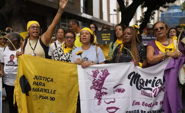 People gather demanding justice before the start of the trial of councilwoman Marielle Franco’s suspected murderers, outside the Court of Justice, in Rio de Janeiro, Brazil, Wednesday, Oct. 30, 2024. (AP Photo/Silvia Izquierdo)