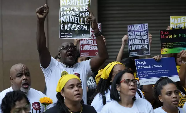 People attend a rally prior to the trial of former Rio de Janeiro city councilwoman Marielle Franco's alleged killers outside the Court of Justice, in Rio de Janeiro, Wednesday, Oct. 30, 2024. (AP Photo/Silvia Izquierdo)