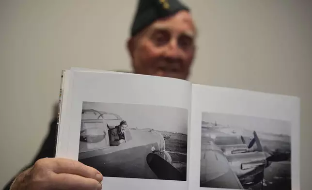 Michael Woods, 100-year-old World War II veteran, shows a photo of himself during an interview in Dunstable, Bedfordshire, England, Tuesday, Nov. 5, 2024. (AP Photo/Kin Cheung)