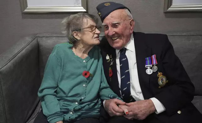 Michael Woods, 100-year-old World War II veteran, chats with his wife Mary during an interview in Dunstable, Bedfordshire, England, Tuesday, Nov. 5, 2024. (AP Photo/Kin Cheung)