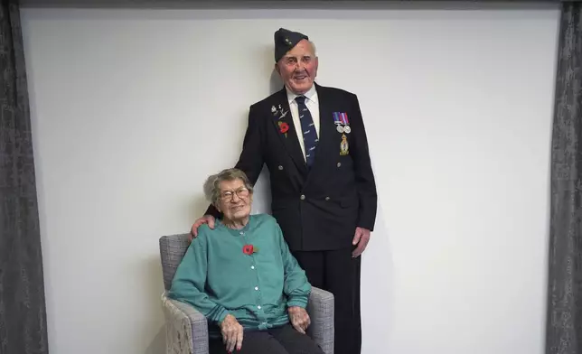 Michael Woods, 100-year-old World War II veteran, poses with his wife Mary during an interview in Dunstable, Bedfordshire, England, Tuesday, Nov. 5, 2024. (AP Photo/Kin Cheung)