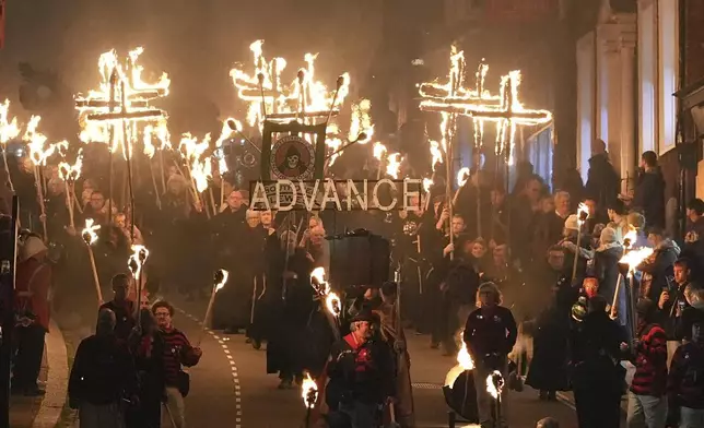 Participants march in the parade through the town of Lewes in East Sussex during an annual bonfire night procession held by the Lewes Bonfire Societies, in Lewes, England, Tuesday Nov. 5, 2024. (Gareth Fuller/PA via AP)