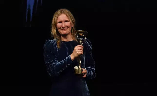 Samantha Harvey poses with the trophy after winning the Booker Prize award 2024, in London, Tuesday, Nov. 12, 2024. (AP Photo/Alberto Pezzali)