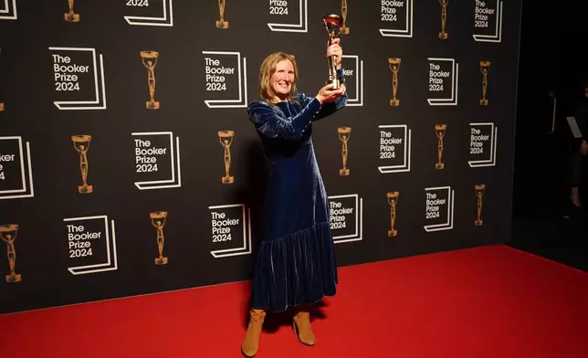 Samantha Harvey poses with the trophy after winning the Booker Prize award 2024, in London, Tuesday, Nov. 12, 2024. (AP Photo/Alberto Pezzali)