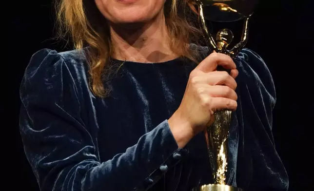 Samantha Harvey poses with the trophy after winning the Booker Prize award 2024, in London, Tuesday, Nov. 12, 2024. (AP Photo/Alberto Pezzali)