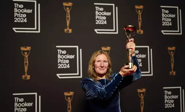 Samantha Harvey poses with the trophy after winning the Booker Prize award 2024, in London, Tuesday, Nov. 12, 2024. (AP Photo/Alberto Pezzali)