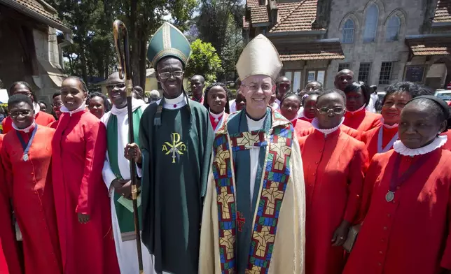 FILE - The Archbishop of Canterbury Justin Welby, center-right, accompanied by Archbishop of Kenya Eliud Wabukala, center-left, poses for a photograph with members of the choir after conducting a service at the All Saints Cathedral in Nairobi, Kenya, Sunday, Oct. 20, 2013. (AP Photo/Ben Curtis, File)