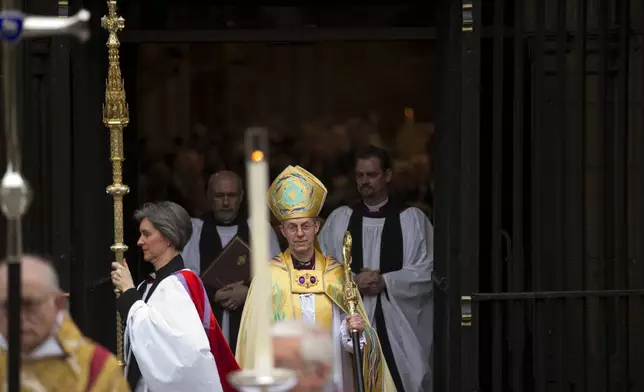 FILE - Britain's new Archbishop of Canterbury Justin Welby, center, leaves after his enthronement ceremony at Canterbury Cathedral in Canterbury, England, Thursday, March 21, 2013. (AP Photo/Matt Dunham, File)