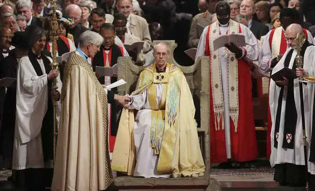 FILE - The Most Reverend Justin Welby sits in the Chair of St Augistine as the Dean of Canterbury Robert Willis takes him by the hand during his enthronement service to become Archbishop of Canterbury at Canterbury Cathedral in Canterbury, England, Thursday, March 21, 2013. (Gareth Fuller, Pool Photo via AP, File)