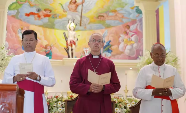 FILE - The Archbishop of Canterbury Justin Welby, center, pays homage to victims of the Easter Sunday attacks at St. Sebastian's church in Katuwapitiya village, Negombo , Sri Lanka, Thursday, Aug. 29, 2019. (AP Photo/Eranga Jayawardena, File)