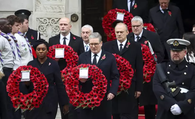 British Prime Minister Keir Starmer, front right, and Conservative Party leader Kemi Badenoch, front left, carry wreaths as they attend the annual Remembrance Sunday ceremony at The Cenotaph in London, England, Sunday, Nov. 10, 2024. (Toby Melville/Pool Photo via AP)