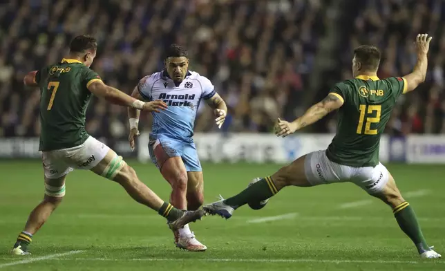 Scotland's Sione Tuipolutu kicks the ball but it is blocked by South Africa's Andre Esterhuizen, right, during the Autumn Nations series rugby union match between Scotland and South Africa in Edinburgh, Scotland, Sunday, Nov. 10, 2024. (AP Photo/Scott Heppell)