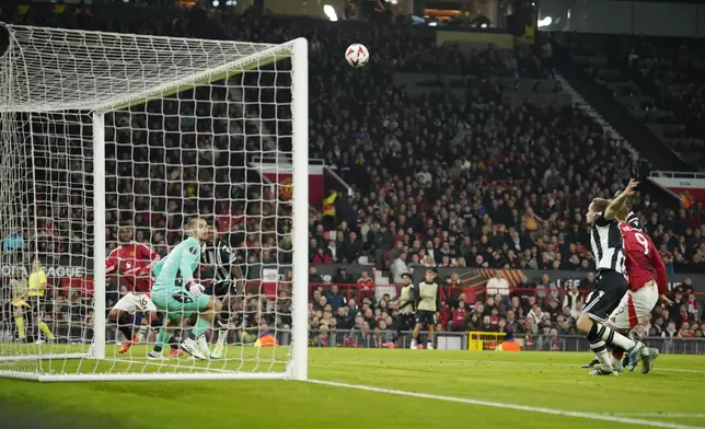 Manchester United's Amad Diallo, left, scores the opening goal during the Europa League opening phase soccer match between Manchester United and PAOK at the Old Trafford stadium in Manchester, England, Thursday, Nov. 7, 2024. (AP Photo/Dave Thompson)