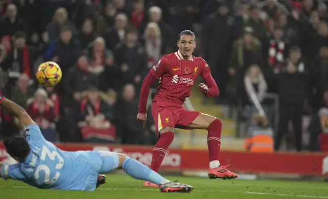 Liverpool's Darwin Nunez, right, scores his side's first goal against Aston Villa's goalkeeper Emiliano Martinez during the English Premier League soccer match at the Anfield stadium in Liverpool, Saturday, Nov. 9, 2024. (AP Photo/Jon Super)