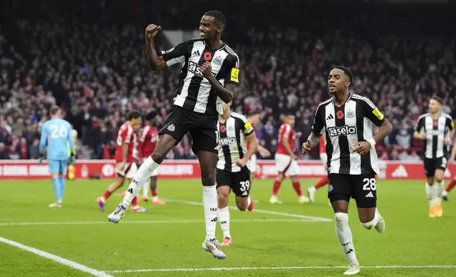 Newcastle United's Alexander Isak, left, celebrates after scoring their side's first goal of the game during the Premier League match between Nottingham Forest and Newcastle United, at the City Ground stadium, Nottingham, England, Sunday Nov. 10, 2024. (Nick Potts/PA via AP)