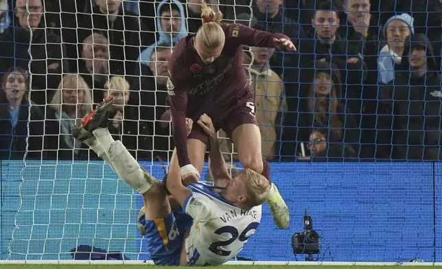 Manchester City's Erling Haaland grabs Brighton's Jan Paul van Hecke during the English Premier League soccer match between Brighton and Manchester City at Falmer Stadium in Brighton, England, Saturday, Nov. 9, 2024. (AP Photo/Alastair Grant)