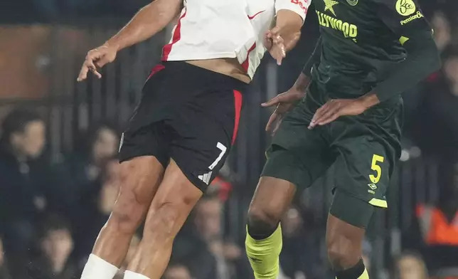 Fulham's Raul Jimenez, left heads the ball under pressure from Brentford's Ethan Pinnock during the English Premier League soccer match between Fulham and Brentford at Craven Cottage stadium in London, Monday, Nov. 4, 2024. (AP Photo/Frank Augstein)