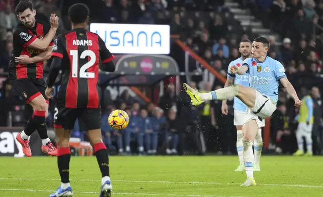 Manchester City's Phil Foden, right, attempts a shot on goal during the English Premier League soccer match between Bournemouth and Manchester City at the Vitality stadium in Bournemouth, England, Saturday, Nov. 2, 2024. (AP Photo/Kirsty Wigglesworth)