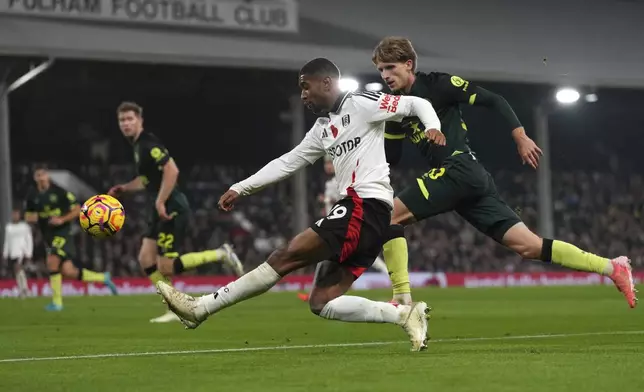 Fulham's Reiss Nelson, left, takes a shot at goal as Brentford's Mads Roerslev defends during the English Premier League soccer match between Fulham and Brentford at Craven Cottage stadium in London, Monday, Nov. 4, 2024. (AP Photo/Frank Augstein)