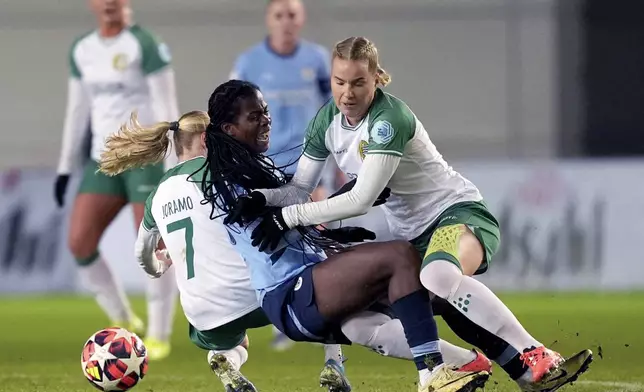 Manchester City's Khadija Shaw, center, is fouled by Hammaby IF's Emilie Joramo, left. and Eva Nystrom, right, during the women's Champions League soccer match between Manchester City FC and Hammarby IF in Manchester, England, Tuesday, Nov. 12, 2024. (Martin Rickett/PA via AP)