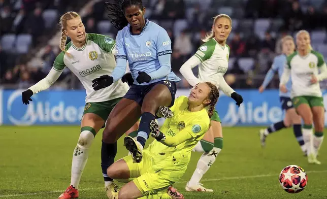 Manchester City's Khadija Shaw, center, and Hammaby IF's Eva Nystrom, left, challenge for the ball during the women's Champions League soccer match between Manchester City FC and Hammarby IF in Manchester, England, Tuesday, Nov. 12, 2024. (Martin Rickett/PA via AP)