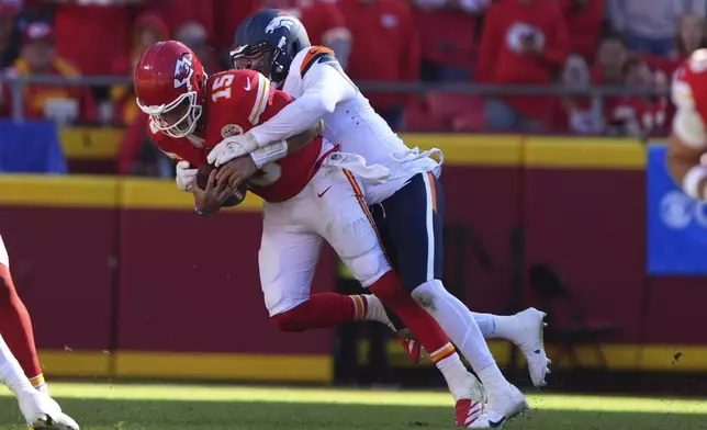 Kansas City Chiefs quarterback Patrick Mahomes (15) is sacked for a 9-yard loss by Denver Broncos outside linebacker Nik Bonitto during the second half of an NFL football game Sunday, Nov. 10, 2024, in Kansas City, Mo. (AP Photo/Charlie Riedel)