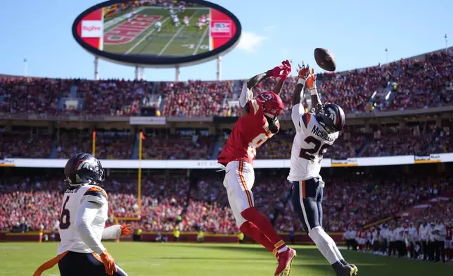 Kansas City Chiefs wide receiver DeAndre Hopkins (8) is unable to catch a pass as Denver Broncos cornerback Ja'Quan McMillian (29) and safety P.J. Locke (6) defend during the first half of an NFL football game Sunday, Nov. 10, 2024, in Kansas City, Mo. (AP Photo/Ed Zurga)