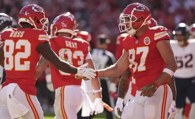 Kansas City Chiefs tight end Travis Kelce (87) is congratulated by Justyn Ross (82) after catching a touchdown pass during the first half of an NFL football game against the Denver Broncos Sunday, Nov. 10, 2024, in Kansas City, Mo. (AP Photo/Charlie Riedel)