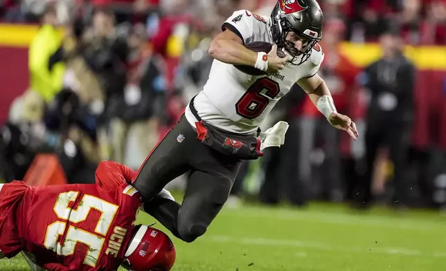 Kansas City Chiefs linebacker Joshua Uche (55) tackles Tampa Bay Buccaneers quarterback Baker Mayfield (6) during the first half of an NFL football game, Monday, Nov. 4, 2024, in Kansas City, Mo. (AP Photo/Charlie Riedel)