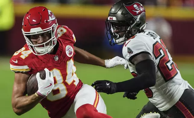 Kansas City Chiefs wide receiver Justin Watson (84) runs against Tampa Bay Buccaneers safety Tykee Smith (23) during the first half of an NFL football game, Monday, Nov. 4, 2024, in Kansas City, Mo. (AP Photo/Charlie Riedel)