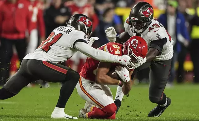 Kansas City Chiefs wide receiver Justin Watson (84) is hit by Tampa Bay Buccaneers linebacker Chris Braswell (43) during the first half of an NFL football game, Monday, Nov. 4, 2024, in Kansas City, Mo. (AP Photo/Charlie Riedel)