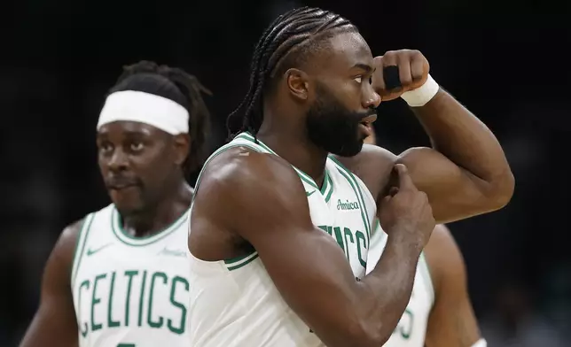 Boston Celtics' Jaylen Brown, right, reacts after scoring during the second half of an NBA basketball game against the Milwaukee Bucks, Monday, Oct. 28, 2024, in Boston. (AP Photo/Michael Dwyer)