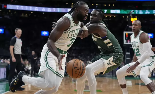 Boston Celtics' Jaylen Brown (7) drives past Milwaukee Bucks' Taurean Prince, center, during the first half of an NBA basketball game, Monday, Oct. 28, 2024, in Boston. (AP Photo/Michael Dwyer)