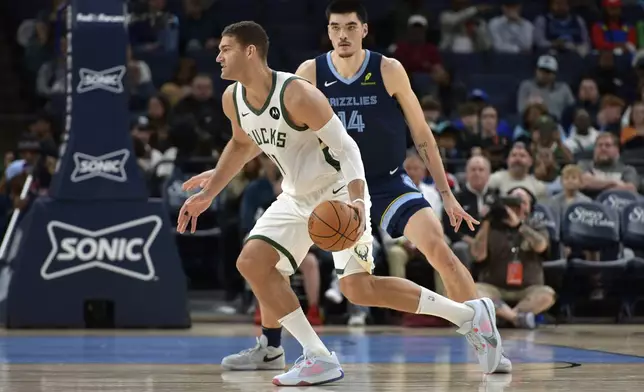 Milwaukee Bucks center Brook Lopez (11) handles the ball against Memphis Grizzlies center Zach Edey (14) in the first half of an NBA basketball game Thursday, Oct. 31, 2024, in Memphis, Tenn. (AP Photo/Brandon Dill)