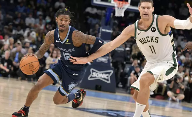 Memphis Grizzlies guard Ja Morant (12) handles the ball against Milwaukee Bucks center Brook Lopez (11) in the first half of an NBA basketball game Thursday, Oct. 31, 2024, in Memphis, Tenn. (AP Photo/Brandon Dill)