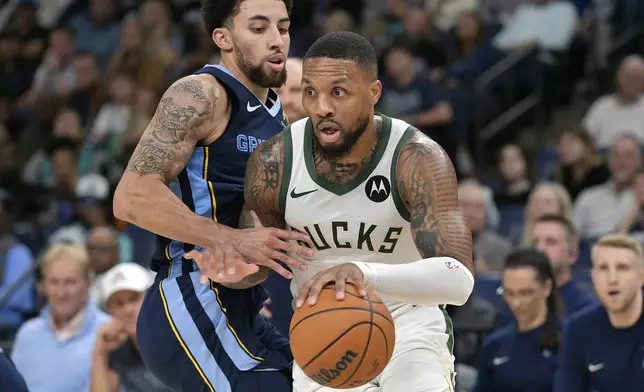 Milwaukee Bucks guard Damian Lillard, right, handles the ball against Memphis Grizzlies guard Scotty Pippen Jr. in the second half of an NBA basketball game Thursday, Oct. 31, 2024, in Memphis, Tenn. (AP Photo/Brandon Dill)