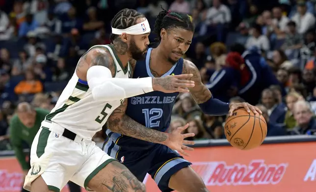 Memphis Grizzlies guard Ja Morant (12) handles the ball against Milwaukee Bucks guard Gary Trent Jr. (5) in the first half of an NBA basketball game Thursday, Oct. 31, 2024, in Memphis, Tenn. (AP Photo/Brandon Dill)