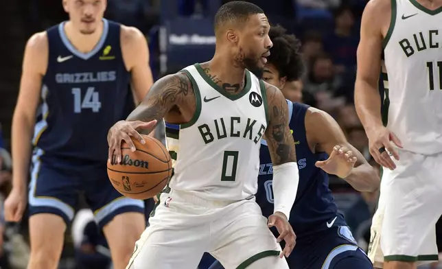 Milwaukee Bucks guard Damian Lillard (0) handles the ball against Memphis Grizzlies forward Jaylen Wells in the first half of an NBA basketball game Thursday, Oct. 31, 2024, in Memphis, Tenn. (AP Photo/Brandon Dill)