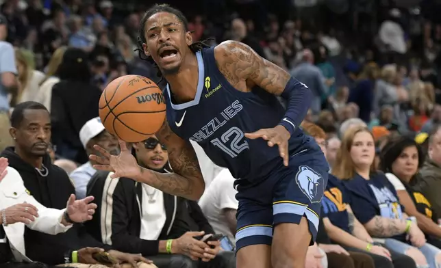 Memphis Grizzlies guard Ja Morant (12) tries to stay inbounds in the first half of an NBA basketball game against the Milwaukee Bucks Thursday, Oct. 31, 2024, in Memphis, Tenn. (AP Photo/Brandon Dill)