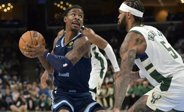 Memphis Grizzlies guard Ja Morant handles the ball against Milwaukee Bucks guard Gary Trent Jr. (5) in the first half of an NBA basketball game Thursday, Oct. 31, 2024, in Memphis, Tenn. (AP Photo/Brandon Dill)