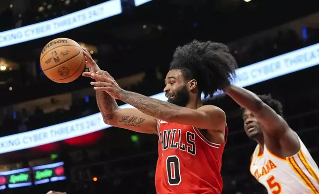 Chicago Bulls guard Coby White (0) passes the ball as Atlanta Hawks center Clint Capela (15) defends during the first half of an NBA basketball game Saturday, Nov. 9, 2024, in Atlanta. (AP Photo/ John Bazemore)