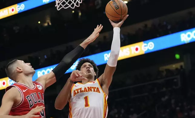 Atlanta Hawks forward Jalen Johnson (1) shoots as Chicago Bulls center Nikola Vucevic (9) defends during the second half of an NBA basketball game Saturday, Nov. 9, 2024, in Atlanta. (AP Photo/John Bazemore)