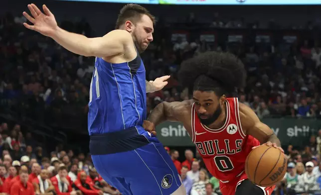 Dallas Mavericks guard Luka Doncic (77) defends as Chicago Bulls guard Coby White (0) drives the ball past in the first half of an NBA basketball game Wednesday, Nov. 6, 2024, in Dallas. (AP Photo/Richard W. Rodriguez)