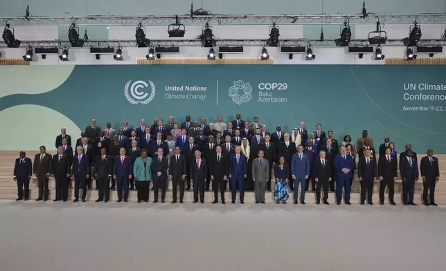 Barbados Prime Minister Mia Mottley, United Kingdom Prime Minister Keir Starmer, Simon Stiell, United Nations climate chief, Antonio Guterres, United Nations secretary-general, Ilham Aliyev, Azerbaijan president, and Turkey President Recep Tayyip, in the center, pose with others for a group photo at the COP29 U.N. Climate Summit, Tuesday, Nov. 12, 2024, in Baku, Azerbaijan. (AP Photo/Peter Dejong)